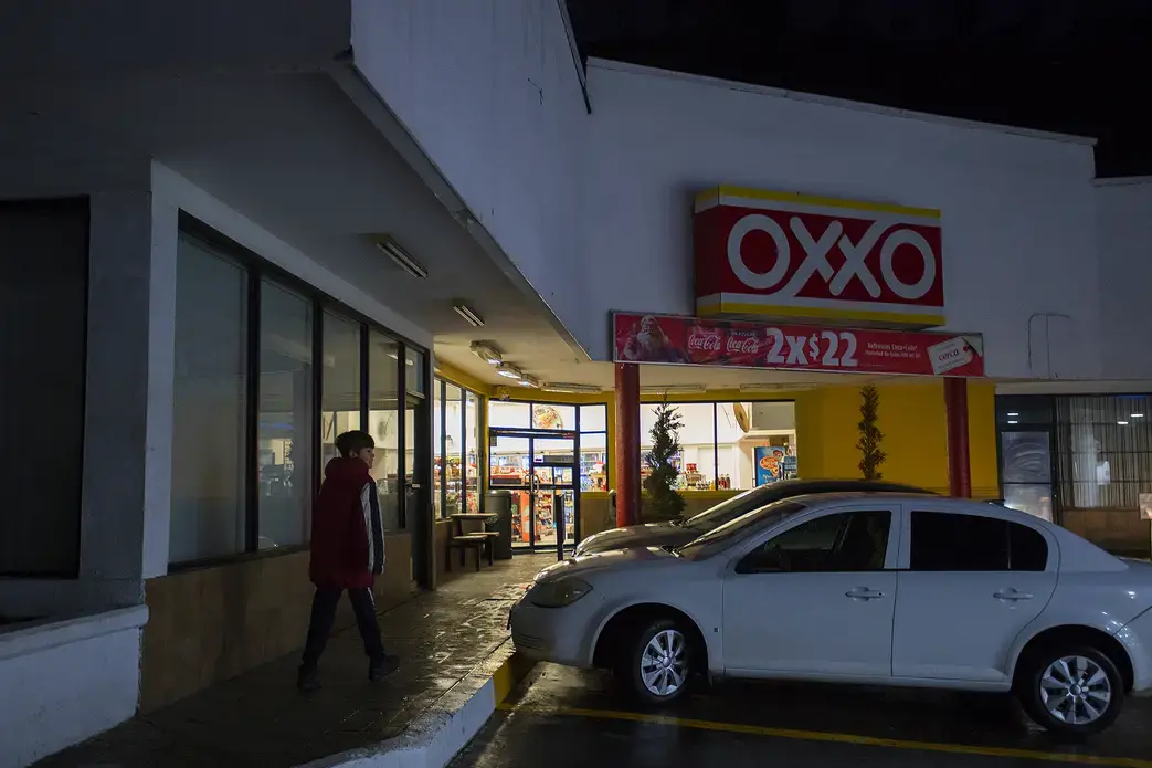 Edward Flores, 12, takes a break from hanging out in his dad's apartment before dinner by stopping by Oxxo, a local convenience store that is next to the complex, for candy with his sisters Thursday, Nov. 28, 2019. Flores and his siblings spend most of their time in the apartment during visits because of safety reasons and lack of money. Image by Amanda Cowan. Mexico, 2019.