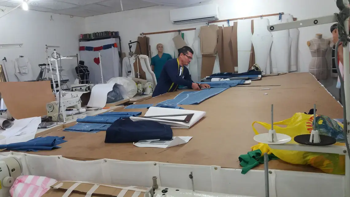 Diosenel Criado was a top tailor for the Farc in the jungle, carrying his sewing machine between camps on a donkey. Now he works from a workshop at the Farc camp in Pondores, La Guajira. Image by Laura Dixon. Colombia, 2018.