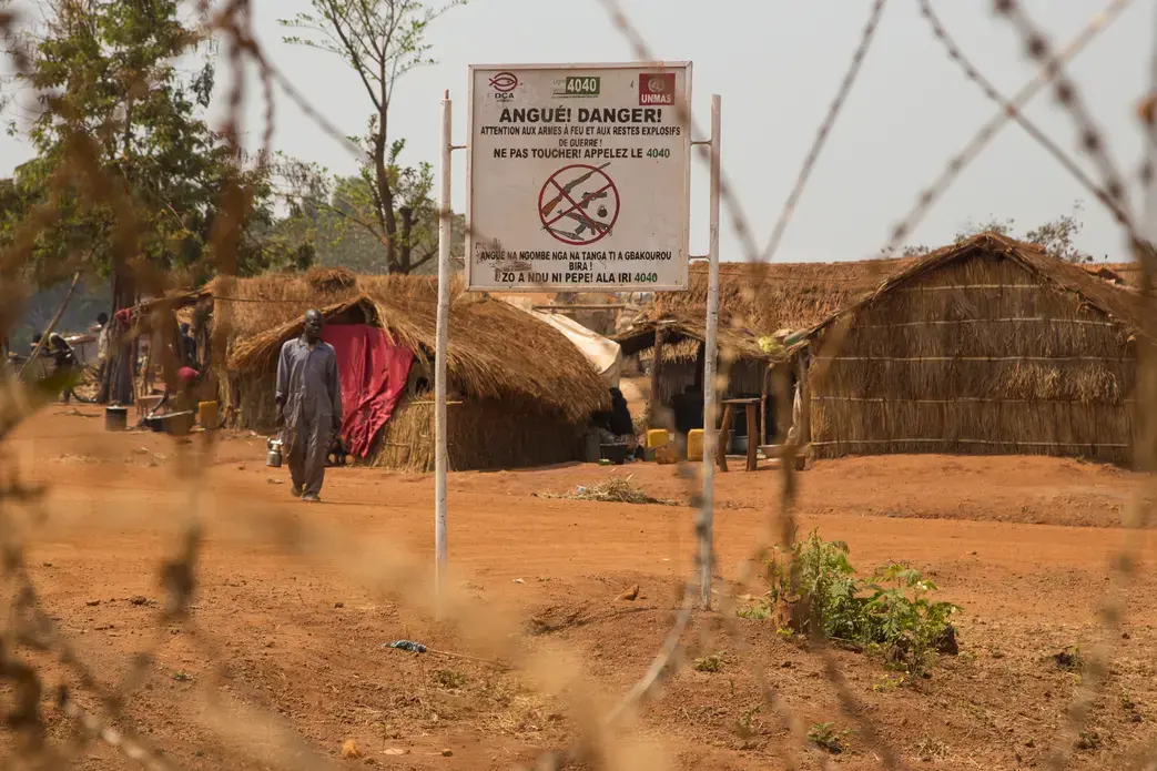 A sign at the entrance to the camp in Bria warns against bringing in weapons. Image by Jack Losh. Central African Republic, 2018.