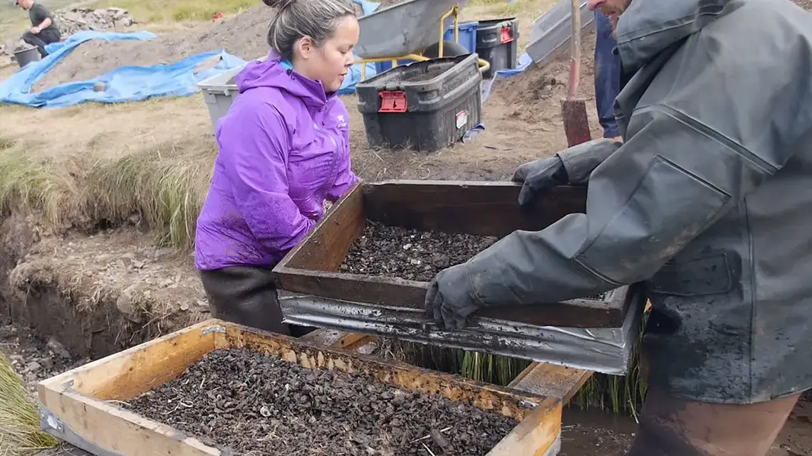 Greenlander Eva Luusi Marcussen-Mølgaard of the University of Greenland in Nuuk (left) washes soil off artifacts. She is one of a handful of students eager to study the archaeology of their homeland. Image by Eli Kintisch. Greenland, 2016.