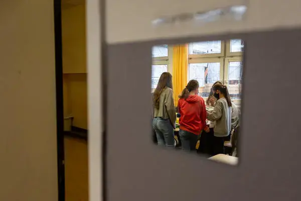 Students working on a book project at the Fritz-Karsen-Shule in Berlin are reflected in a mirror on the classroom wall. Image by Ryan Delaney. Germany, 2020.