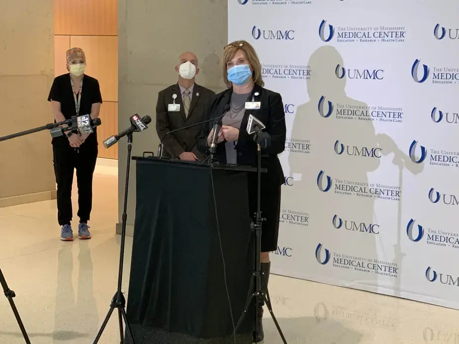 During a news conference Monday, Nov. 23, 2020, Dr. LouAnn Woodward (at podium), vice chancellor for health affairs and dean of the School of Medicine at the University of Mississippi Medical Center, calls for the statewide mask mandate to be resumed. Image courtesy of UMMC. United States, 2020.