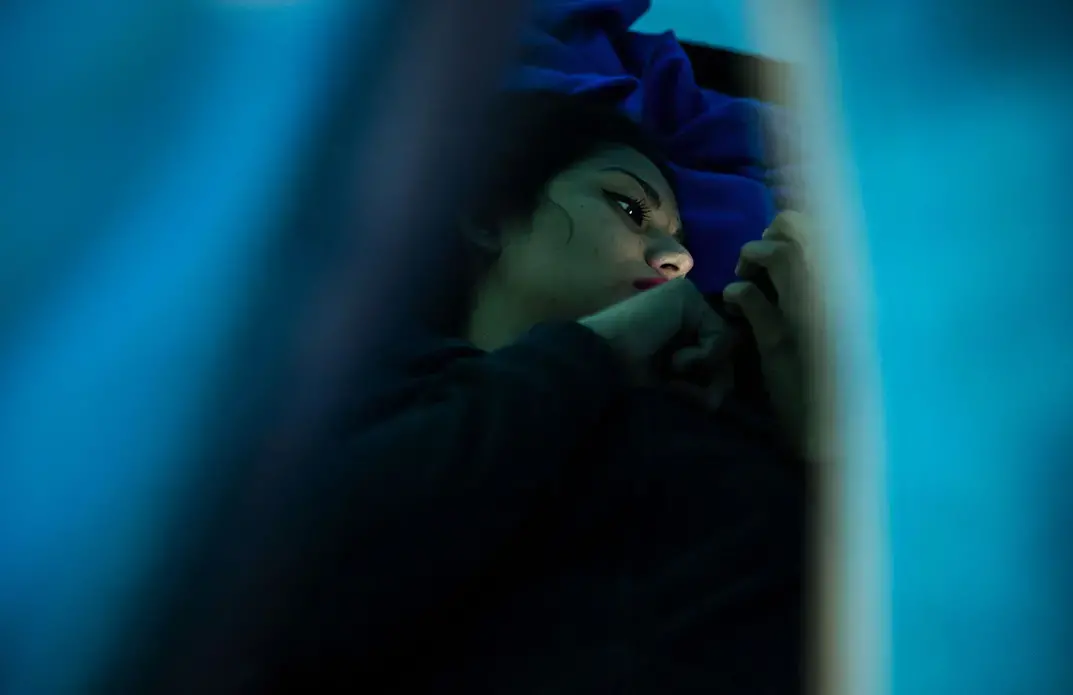 Gabriela, 22, left, and friend Daniela, 19, talk in a shelter in Tijuana. Gabriela, mother of two children, was shot several times in El Salvador. They talked about the risks women can face in their home country, including sexual assault, violence and death. The women fled and were in the process of applying for asylum. Image by Erika Schultz. Mexico, 2019.