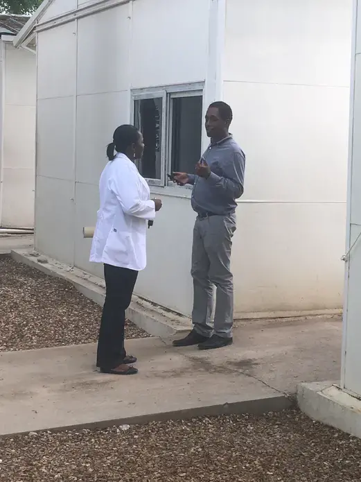 Dr, Joesph Bernard, left, takes a moment to discuss patient care with a fellow physician in training. Image by Kate Corrigan. Haiti, 2017. 