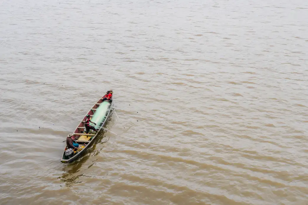 A man and his son fishing with a pirogue in the Wouri river, near the port of Douala. Image by Sidoine Mbogni/Shutterstock. Cameroon, 2019.