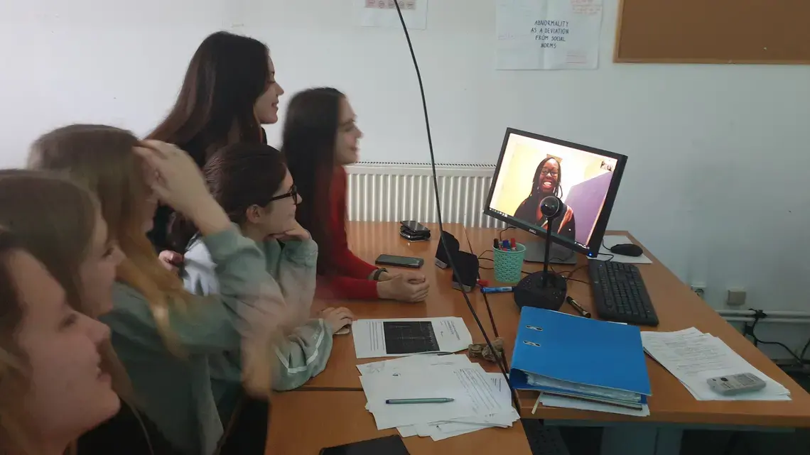 Students gather around a computer to listen to Erica Ayisi present.