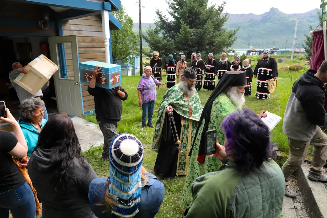 A man carries a small blue coffin at a Native American ceremony