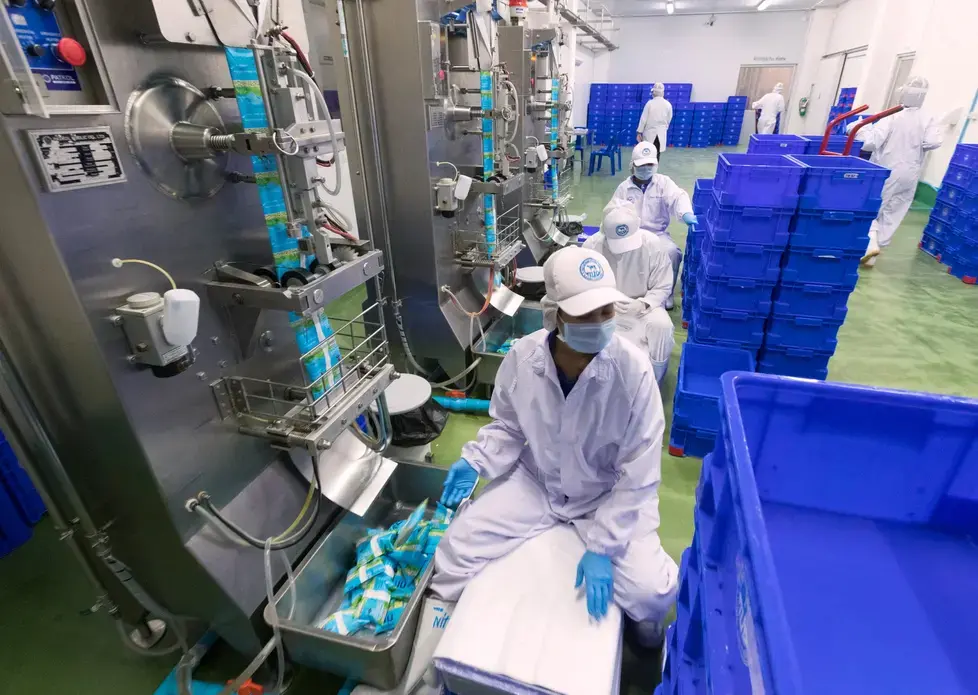 Milk is packaged at the Dairy Farming Promotion Organization in Pak Chong, Thailand. Image by Mark Hoffman. Thailand, 2019.