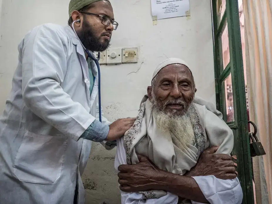 A lung specialist listens to the raspy breathing of a patient. Dr. Wahid says asthma is the most common pollution-related disease he sees. Image by Larry C. Price. Bangladesh, 2018.