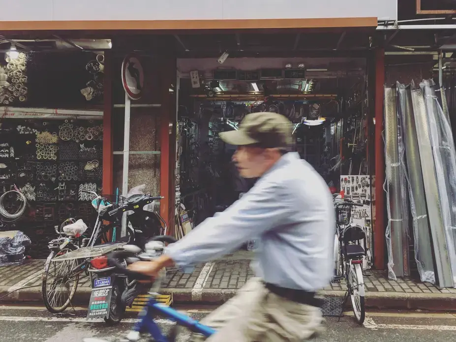 A man rides his bike past a hardware store on Sunday morning, Oct. 1, 2017, in Shanghai. Image by Kelsey Kremer. China, 2017.