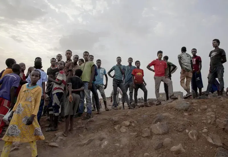 Ethiopian migrants stand on a hill at a slum in Dikhil, Djibouti, where they took shelter after entering the country, July 12, 2019, on their journey to Yemen. Most hope to eventually reach Saudi Arabia. Image by AP Photo /&nbsp;Nariman El-Mofty. Djibouti, 2019.