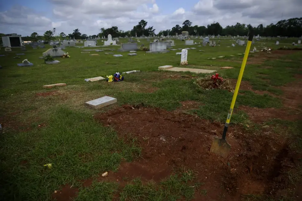 A shovel sits in a freshly-covered grave at the Cedar Hill Cemetery on Saturday, April 18, 2020, in Dawson, Ga. Image by Brynn Anderson / AP Photo. United States, 2020.