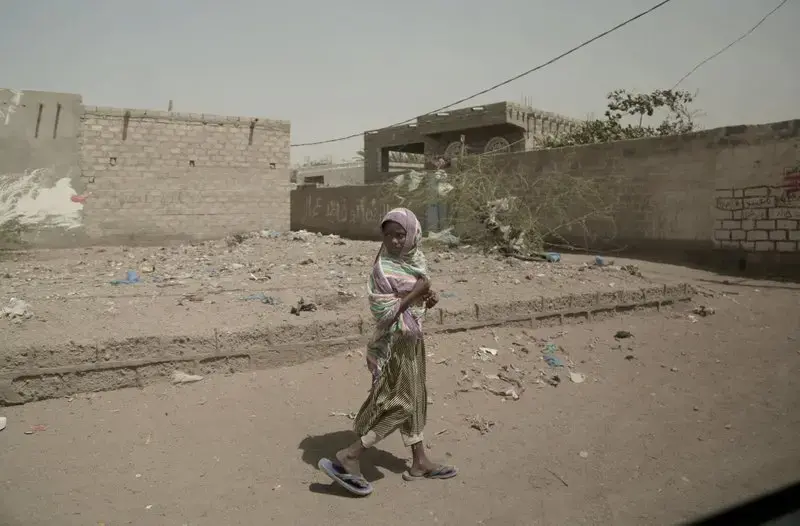 In this Feb. 12, 2018, photo, a girl walks alone on a street in al-Khoukha, Yemen. Since the Saudi-led coalition began its bombing campaign against the rebels in 2015, the U.N. estimates that some 10,000 civilians have been killed. Millions need humanitarian assistance and have been forced to flee their homes. Image by Nariman El-Mofty. Yemen, 2018. </p>
<p>
