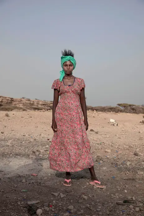 In this July 15, 2019 photo, 15-year-old Willo, a migrant from Ethiopia, poses for a portrait as she and others rest on the last stop of their journey before leaving by boat to Yemen in the evening, in Obock, Djibouti. Image by Nariman El-Mofty / AP Photo. Djibouti, 2019.