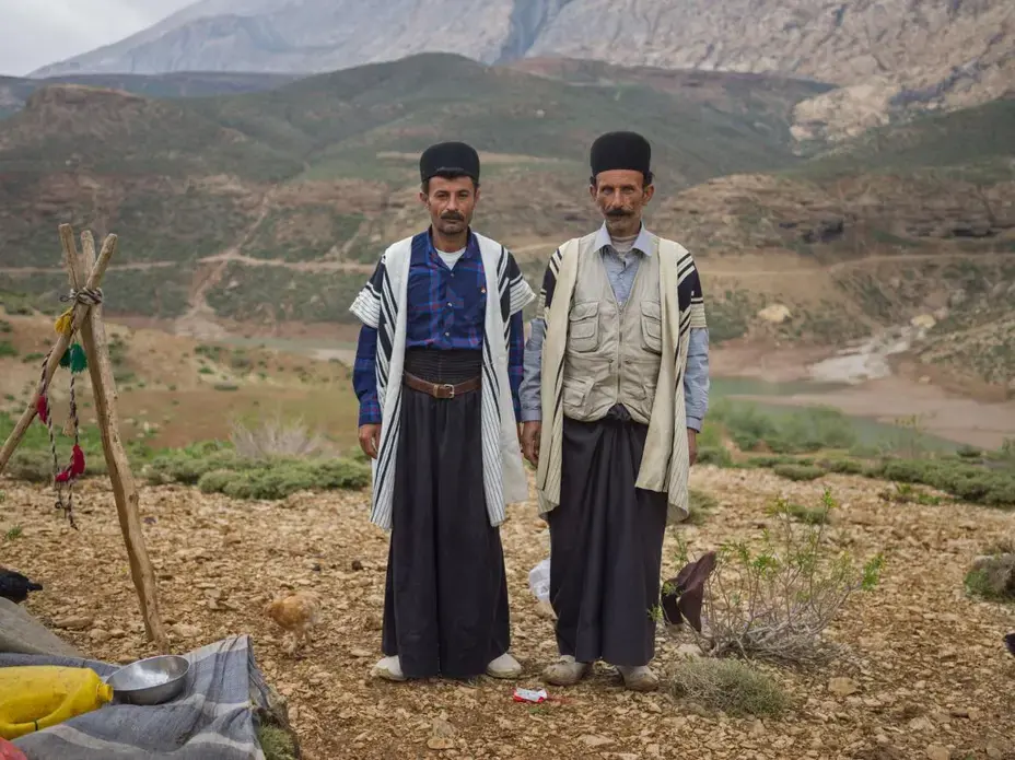 Ali Hasan Darvishi (left), 40, stands with a relative, Ali Ahmad Ghorbani, at the front of the Darvishi family’s tent. Darvishi fell in love with his wife in school. Image by Newsha Tavakolian. Iran, 2018.