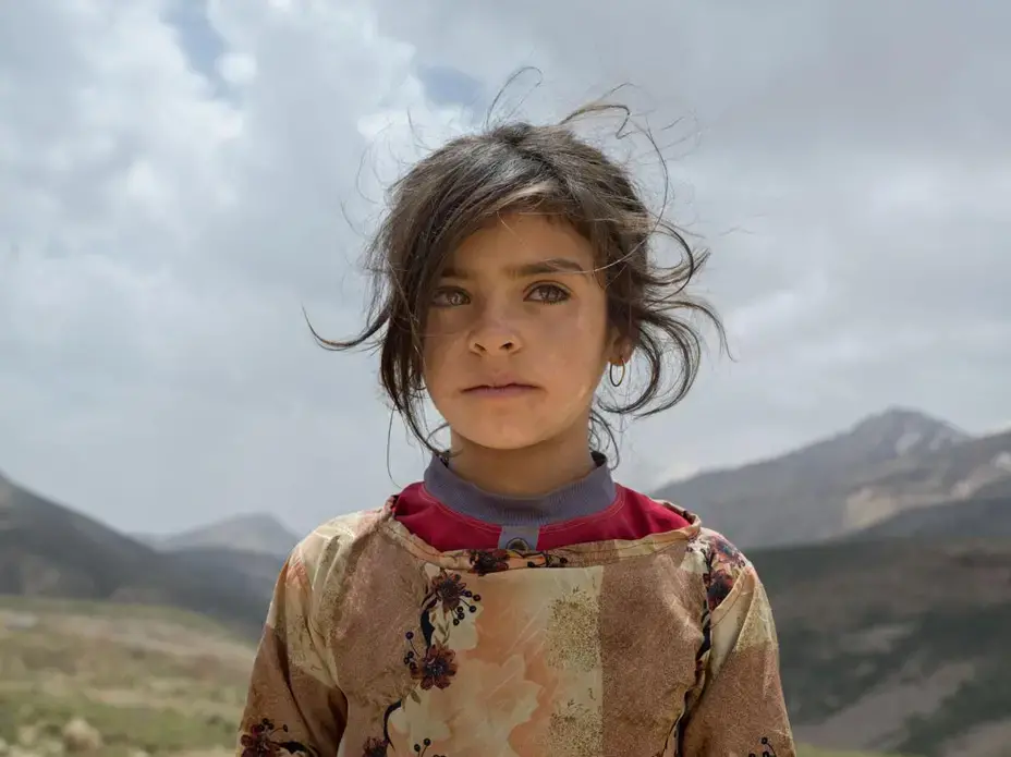 Marzieh Seyfouri, eight, and her family just arrived from Khuzestan Province to find grass and water on Zard Mountain to feed their flock. She doesn’t like her family’s tent but loves attending school in Khuzestan. Image by Newsha Tavakolian. Iran, 2018.