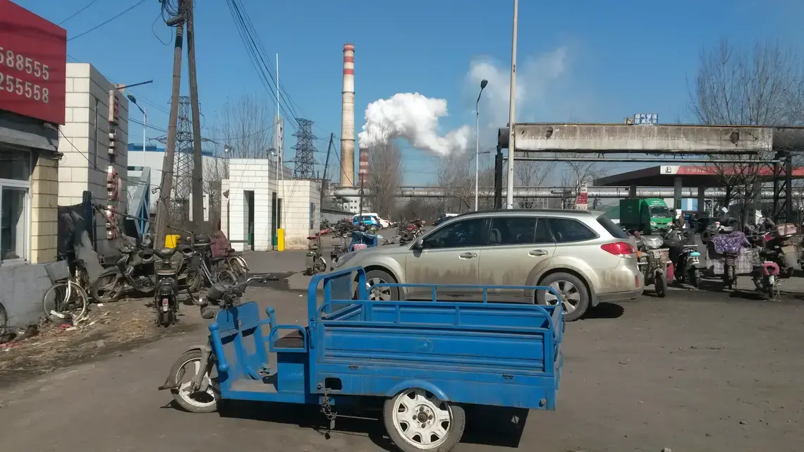 This photo of the Tangshan Guofeng Steel and Iron Factory was taken from outside the small shop and restaurant where I interviewed Wang Jing Bo, a worker who has mixed feelings about his job in the mill. Image by Beth Gardiner. China, 2017. 