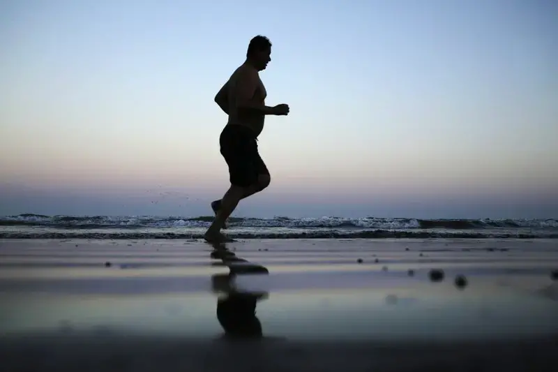 In this Feb. 13, 2018, photo, a man jogs on the beach after the sun sets in Aden, Yemen. Image by Nariman El-Mofty. Yemen, 2018.</p>
<p>