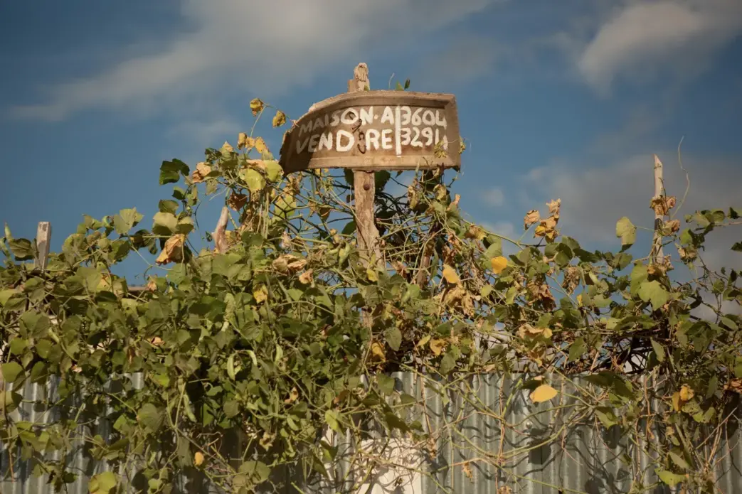 A sign advertises a home for sale in the Canaan 2 neighborhood. Image by Allison Shelley. Haiti, 2019.