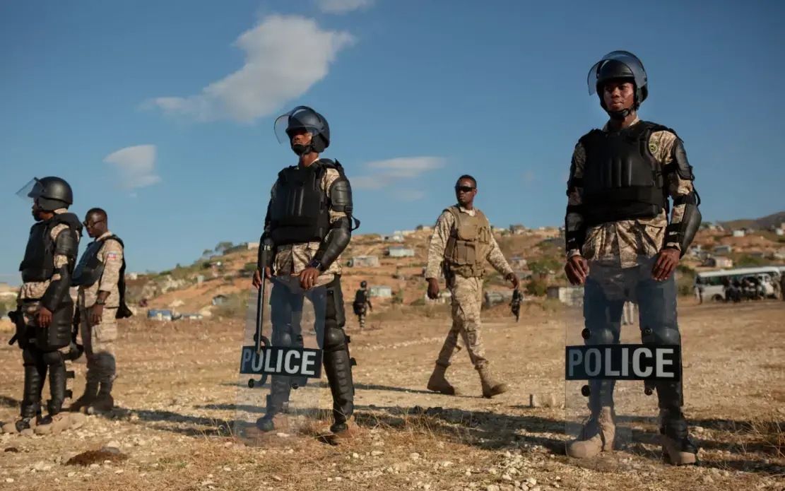 Haitian police stand guard outside the St. Christophe memorial. The mass gravesite where tens of thousands of earthquake victims are buried, in preparation for the annual wreath-laying by Haitian president Jovenel Moïse. Image by Allison Shelley. Haiti, 2019.