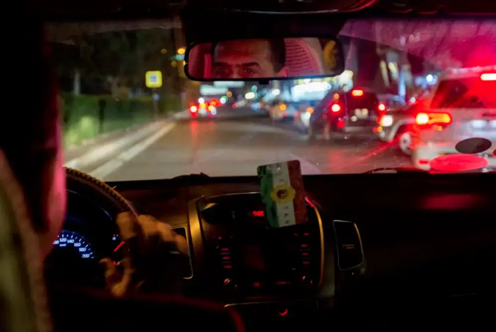 Dr. Faris keeps his eyes on the road as he drives Zahra Ahmad, his niece, to his home to meet the rest of his family for the first time in Erbil, Iraqi-Kurdistan on Feb. 4, 2019. Najar is an assistant professor at Erbil Polytechnic University. He is also the head of the highway engineering department and is responsible for the city's successful highway system. Image by Brontë Wittpenn. Iraq, 2019.