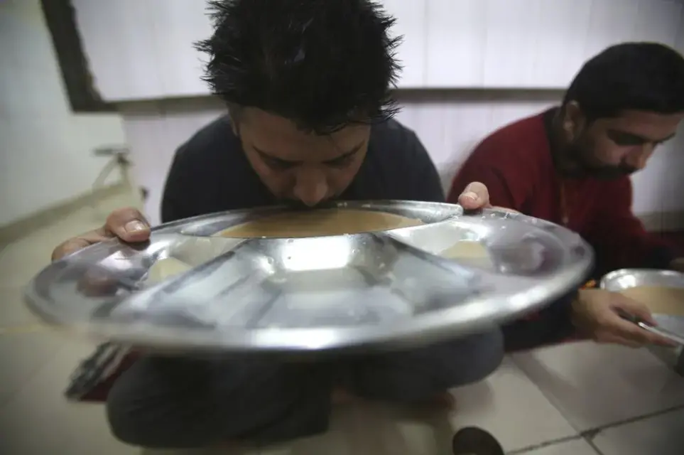 In this Thursday, Oct. 31, 2019, photo, recovering drug users eat a meal at a de-addiction center in Kapurthala, in the northern Indian state of Punjab. India has twice the global average of illicit opiate consumption. Researchers estimate 4 million Indians use heroin or other opioids, and a quarter of them live in the Punjab, India’s agricultural heartland bordering Pakistan, where some of the most vulnerable are driven to drugs out of desperation. Image by Channi Anand / AP Photo. India, 2019.