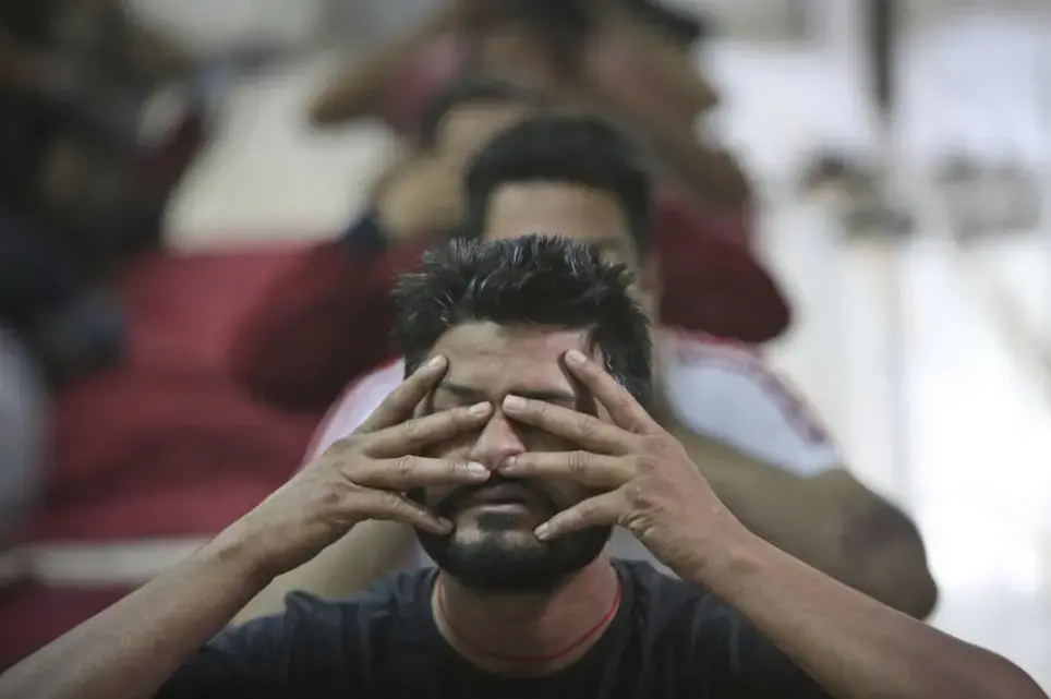 In this Thursday, Oct. 31, 2019, photo, recovering drug users perform yoga at a de-addiction center in Kapurthala, in the northern Indian state of Punjab. India has twice the global average of illicit opiate consumption. Researchers estimate 4 million Indians use heroin or other opioids, and a quarter of them live in the Punjab, India’s agricultural heartland bordering Pakistan, where some of the most vulnerable are driven to drugs out of desperation. Image by Channi Anand / AP Photo. India, 2019.