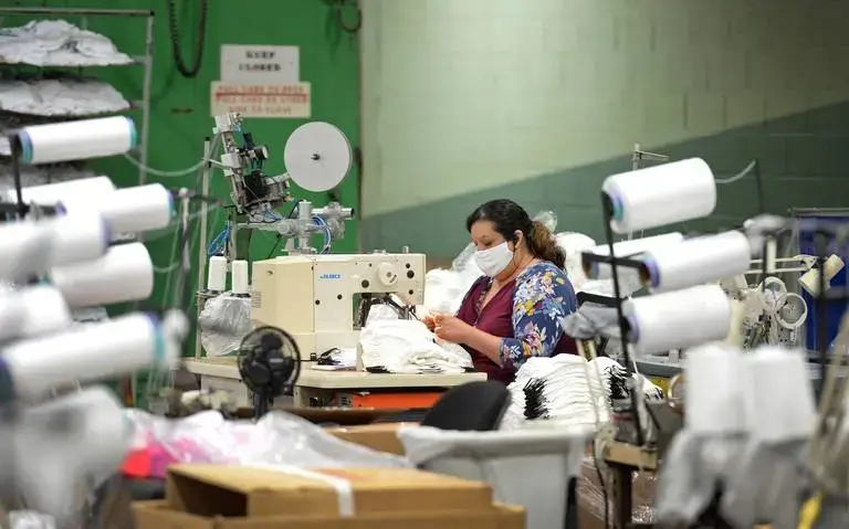 ASHEBORO, NORTH CAROLINA - Maria Reyes Alonso, sewer, at the Bossong Medical plant in Asheboro, N.C. sews elastic bands onto masks on Thursday, July 16, 2020. Image by Jeff Siner/The Charlotte Observer/North Carolina News Collaborative. United States, 2020.