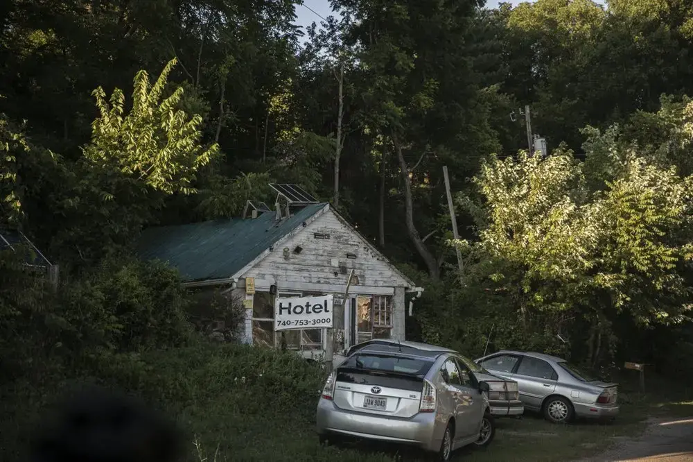 Cars are parked in front of a building with a banner which reads 'Hotel' in front in Shawnee, Ohio. Image by Wong Maye-E/AP Photo. United States, 2020.