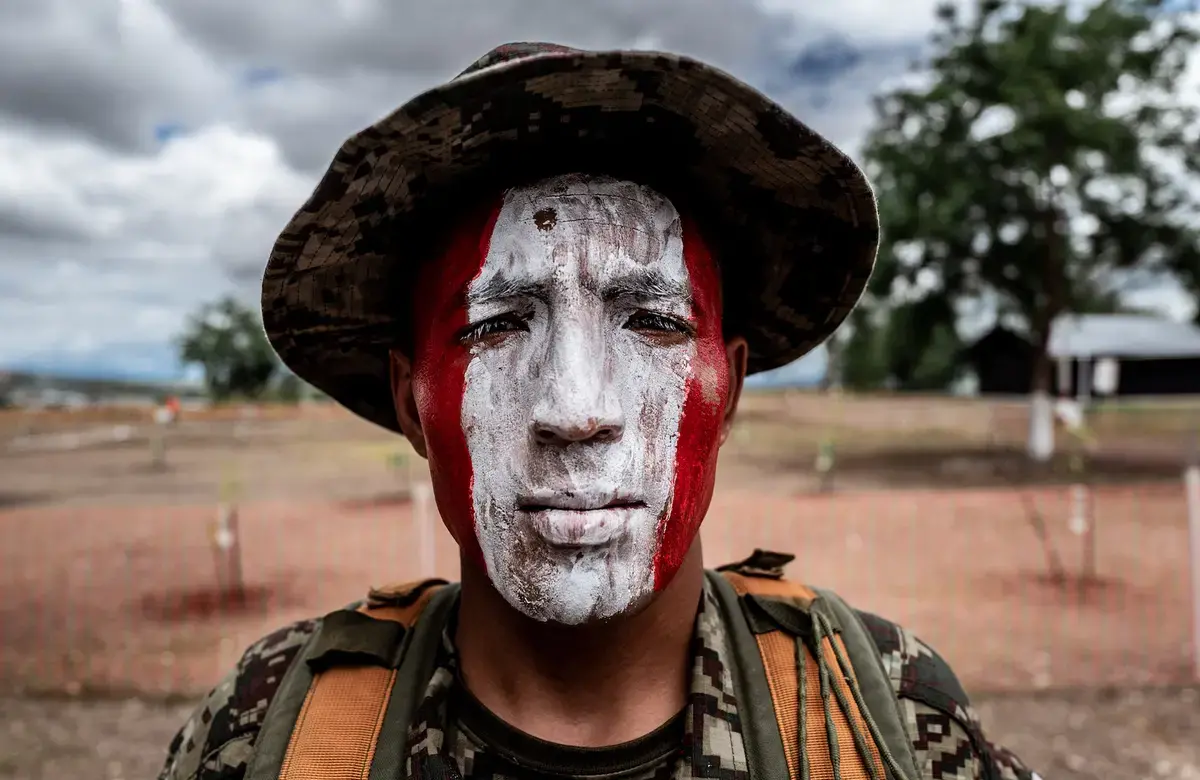 a man with red and white face paint faces the camera directly