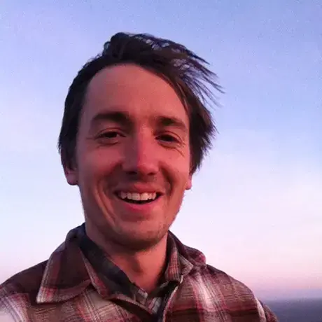 Photo of Nate Hegyi in plaid shirt at sunset
