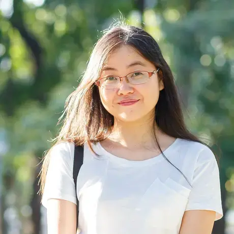 A person wears glasses and a white shirt.