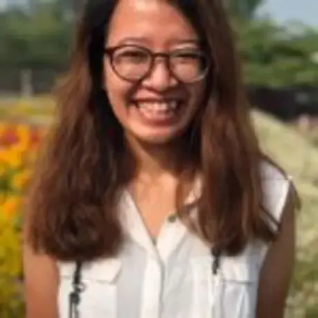 Lusia.jpeg A woman with glasses and wearing a white shirt smiles into the camera.