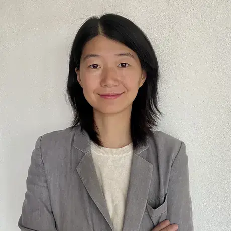 A person wears a grey jacket and a white shirt.