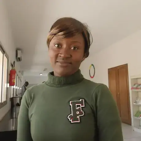 A woman with brown hair is wearing a dark green sweatshirt with the letter F.