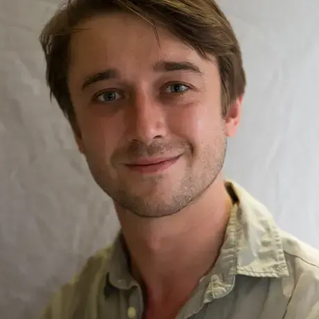 A person wears a green work shirt with buttons.