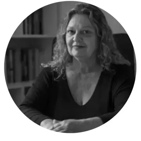 Marina Amaral.png a woman with curly hair stares into the camera