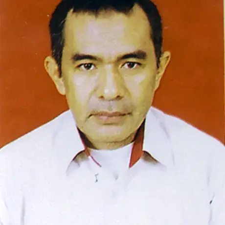 A person with short black hair and a white work shirt.