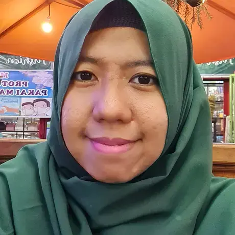 12_12_2021-7_24_23-PM.jpg a woman with a green hijab stares into the camera