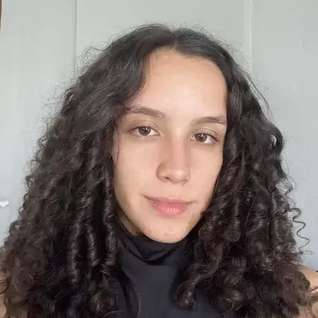 Laura-Scofield.jpg a woman with curly hair looks into the camera