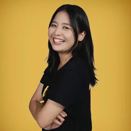 Ploythida beams at the camera with her arms folded.