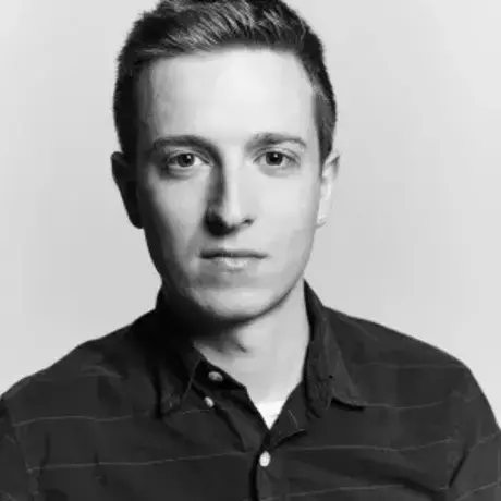Black and white headshot of a man with short hair wearing a collared shirt.