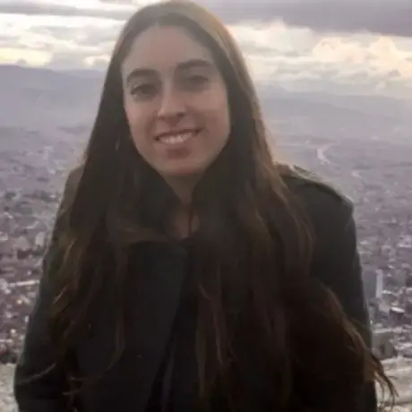 Isbale smiles at the camera against a stunning view of a city.