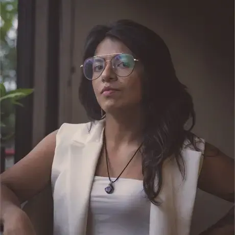 Headshot of Jessica wearing glasses and a white vest