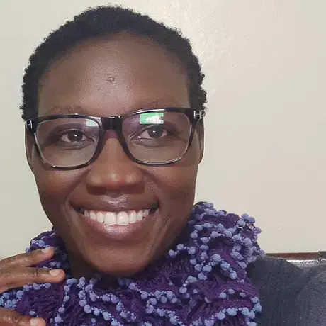 Image of Moraa wearing glasses and a purple scarf