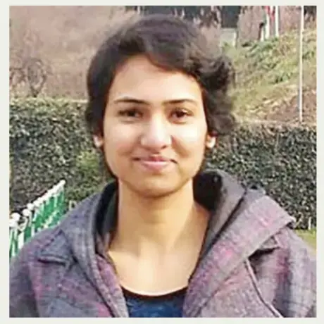 Headshot of Rishika wearing a grey jacket