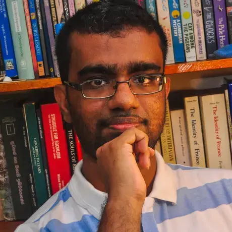 Headshot of Uditha wearing a striped shirt
