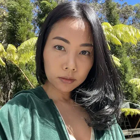 Chayanee Brooks is an Asian Woman with Black hair. She is posed outdoors looking into the camera.