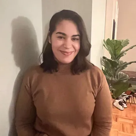 Tatiana Acuna, a Latina woman with short brown hair smiles into the camera.