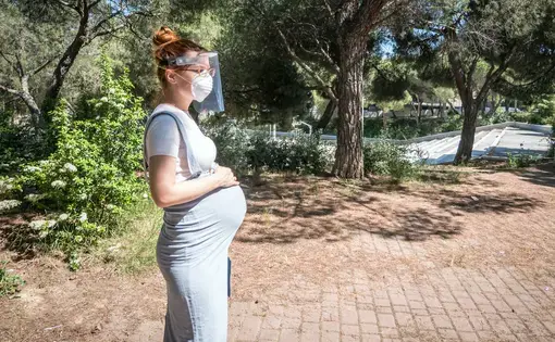 A pregnant woman goes for a walk in a public park in Madrid. Image by JoeLogan / Shutterstock. Spain, 2020.